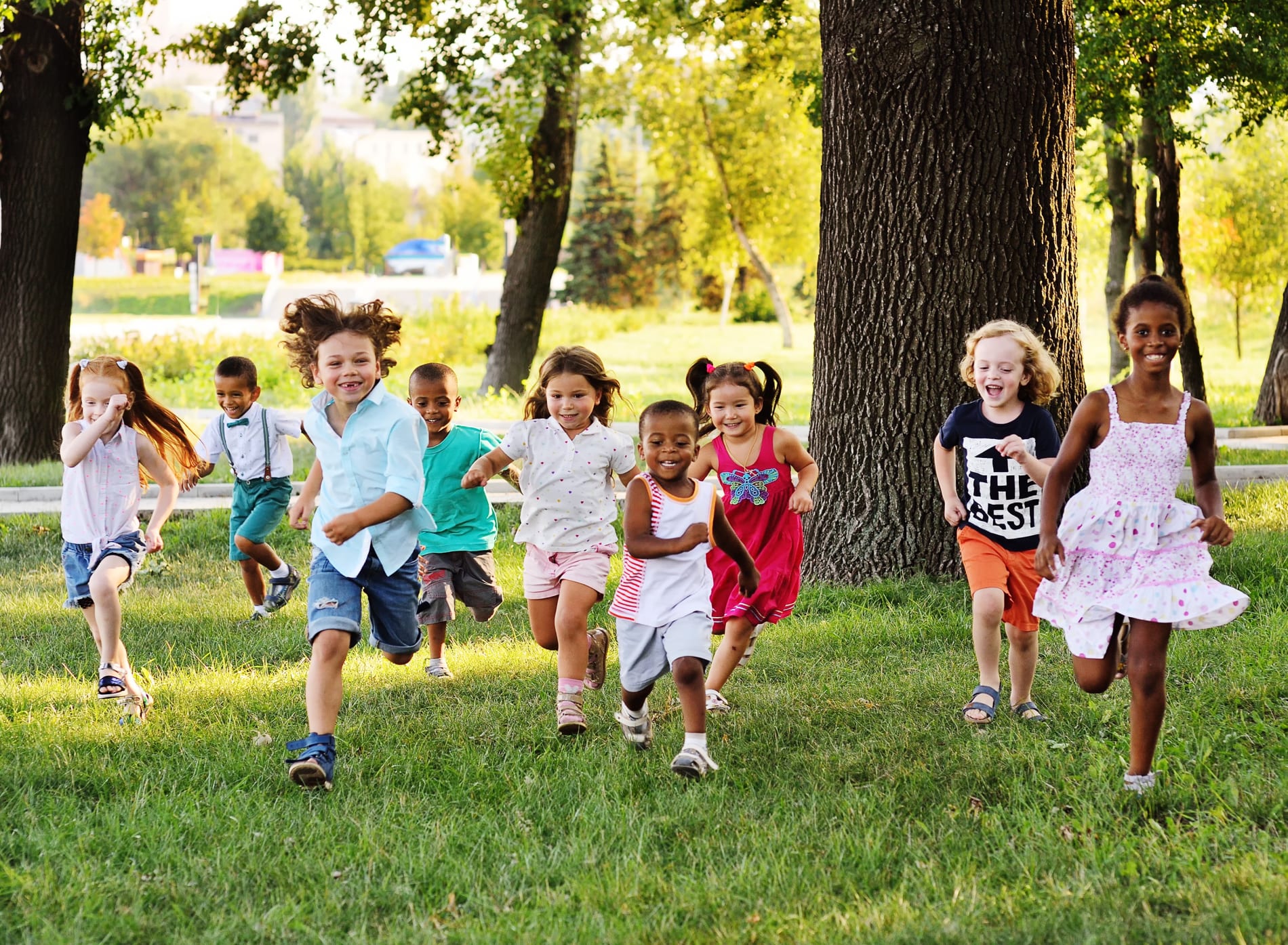 Group of young children running on grass