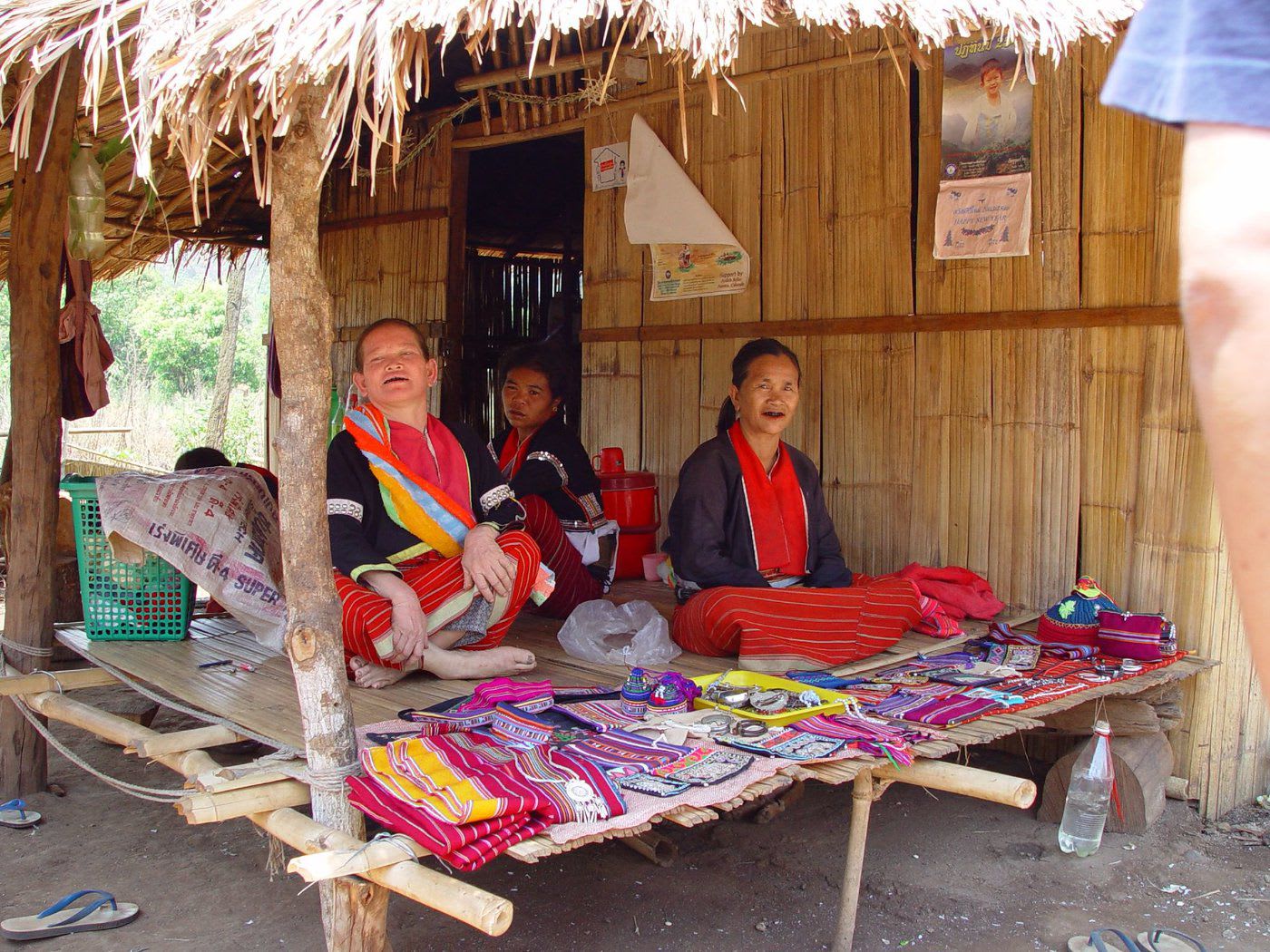Women sitting in a hut selling textiles.