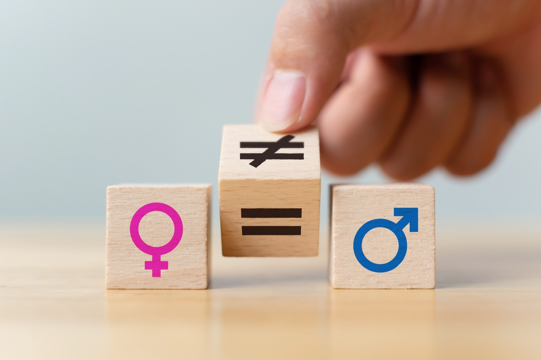 gender equality concept. Hand flip wooden cube with symbol unequal change to equal sign