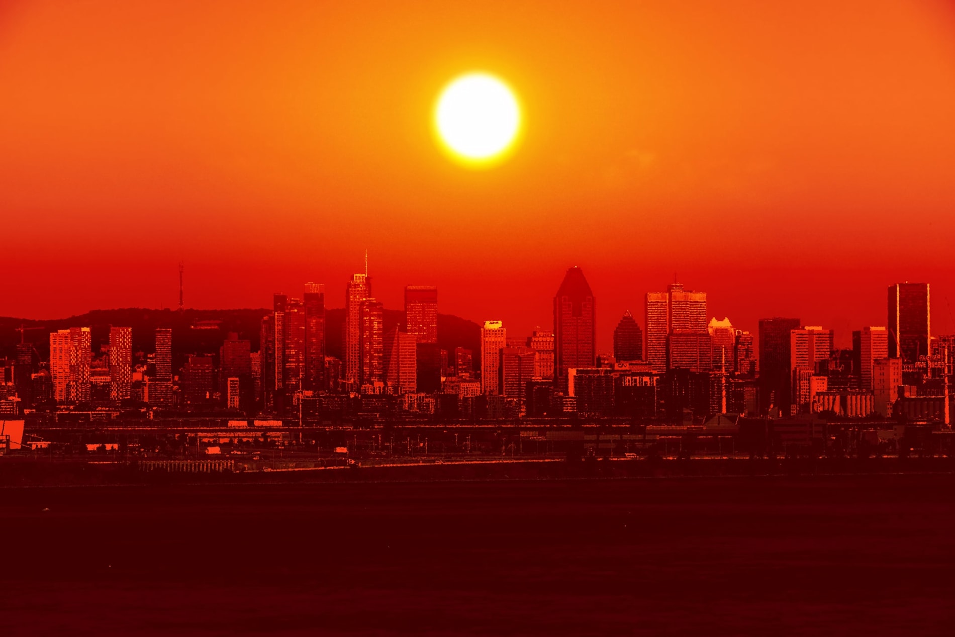 Conceptual image of a cityscape hit by an extreme heatwave with the sun hovering over it