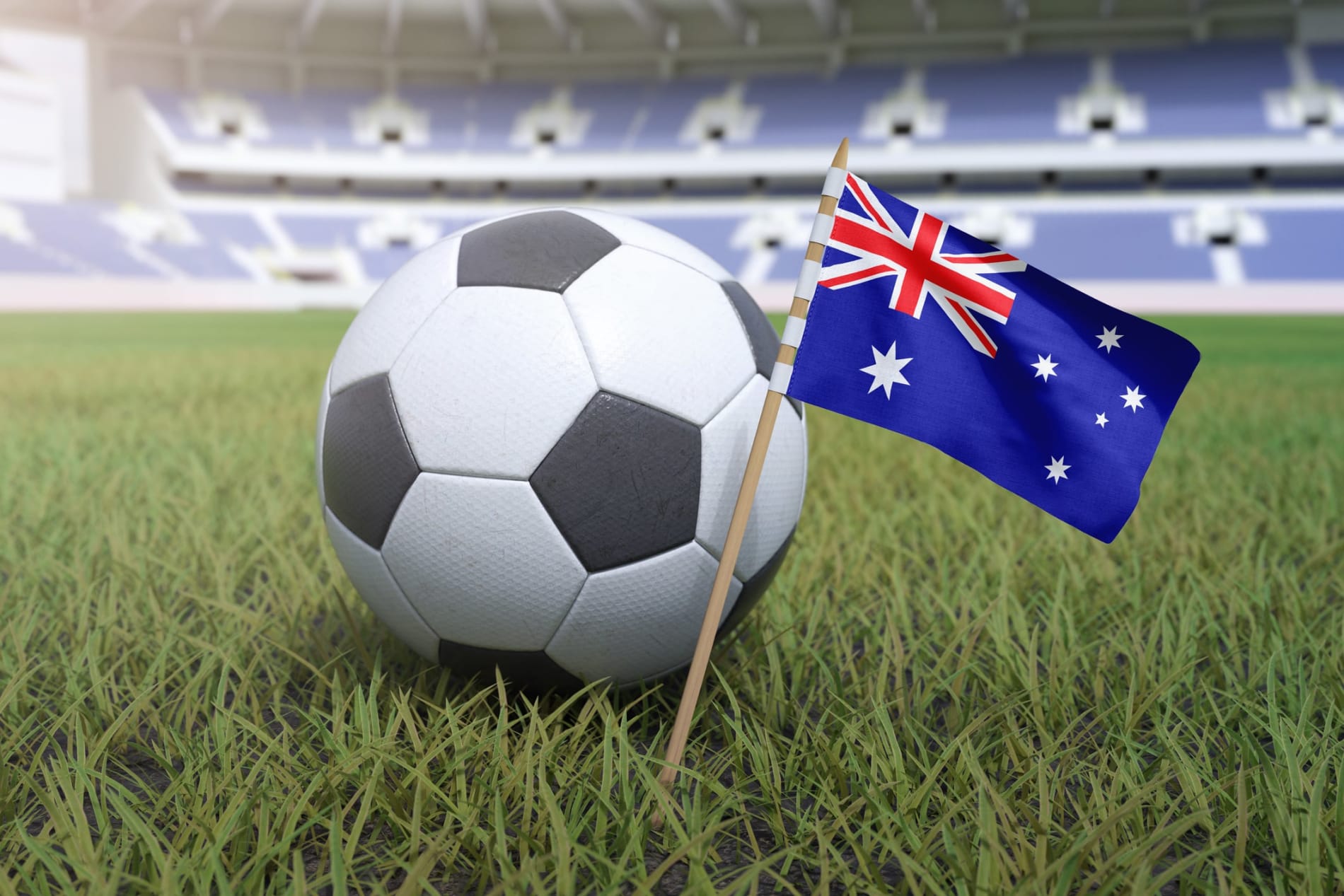 Australian flag in football stadium field with soccer ball on grass