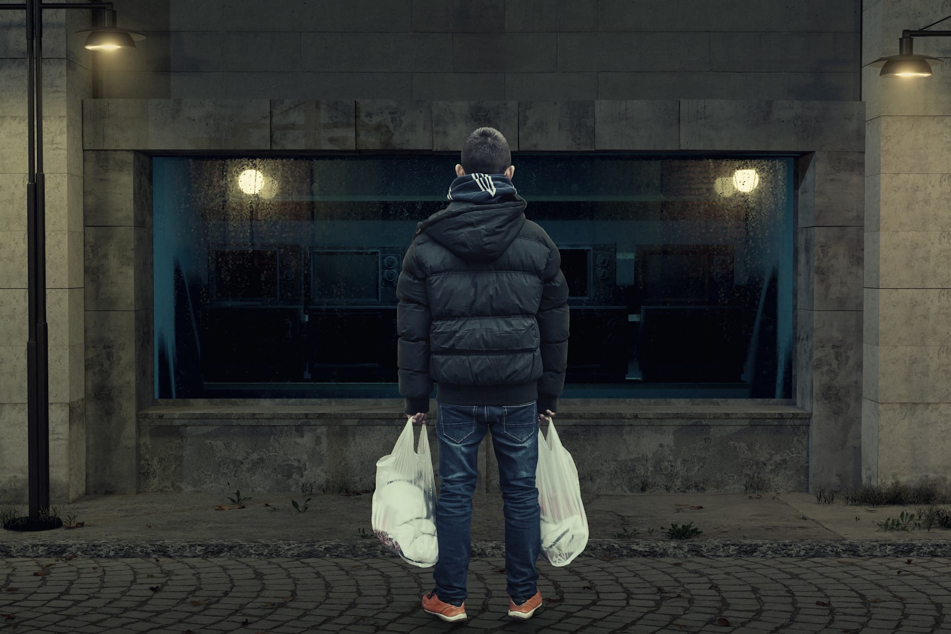 back of teen with white plastic bags in his hands on the street.