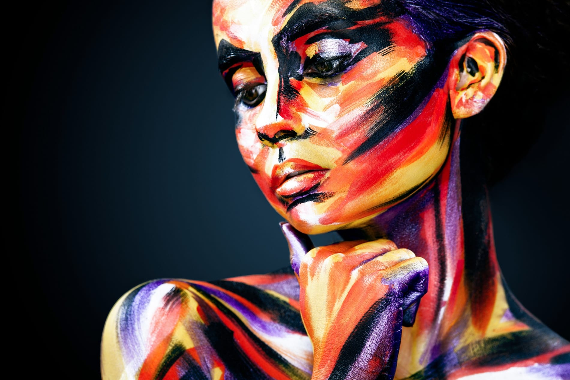 Portrait of the bright beautiful young woman with art make-up on dark background