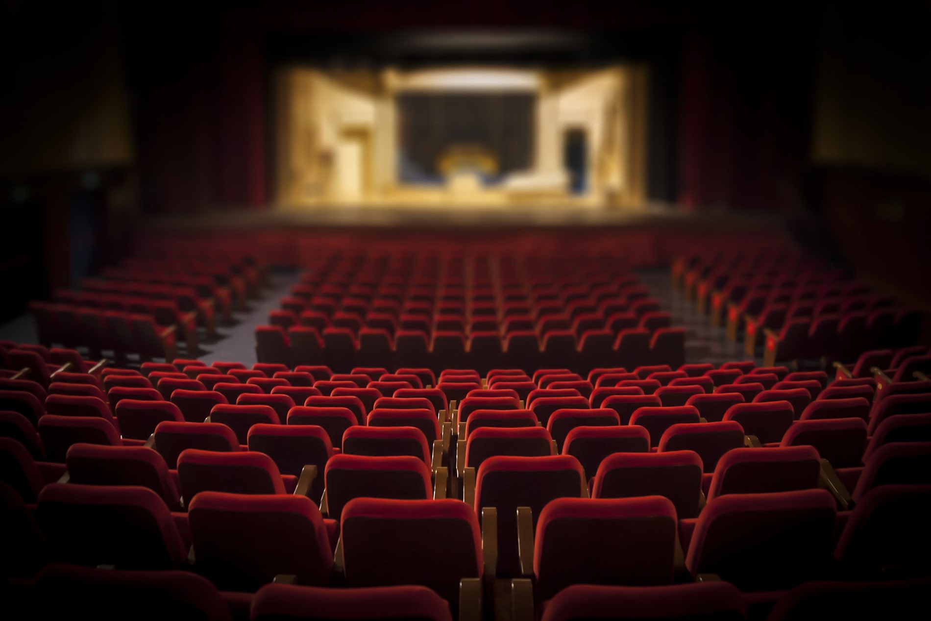 An empty theatre with plush red seats