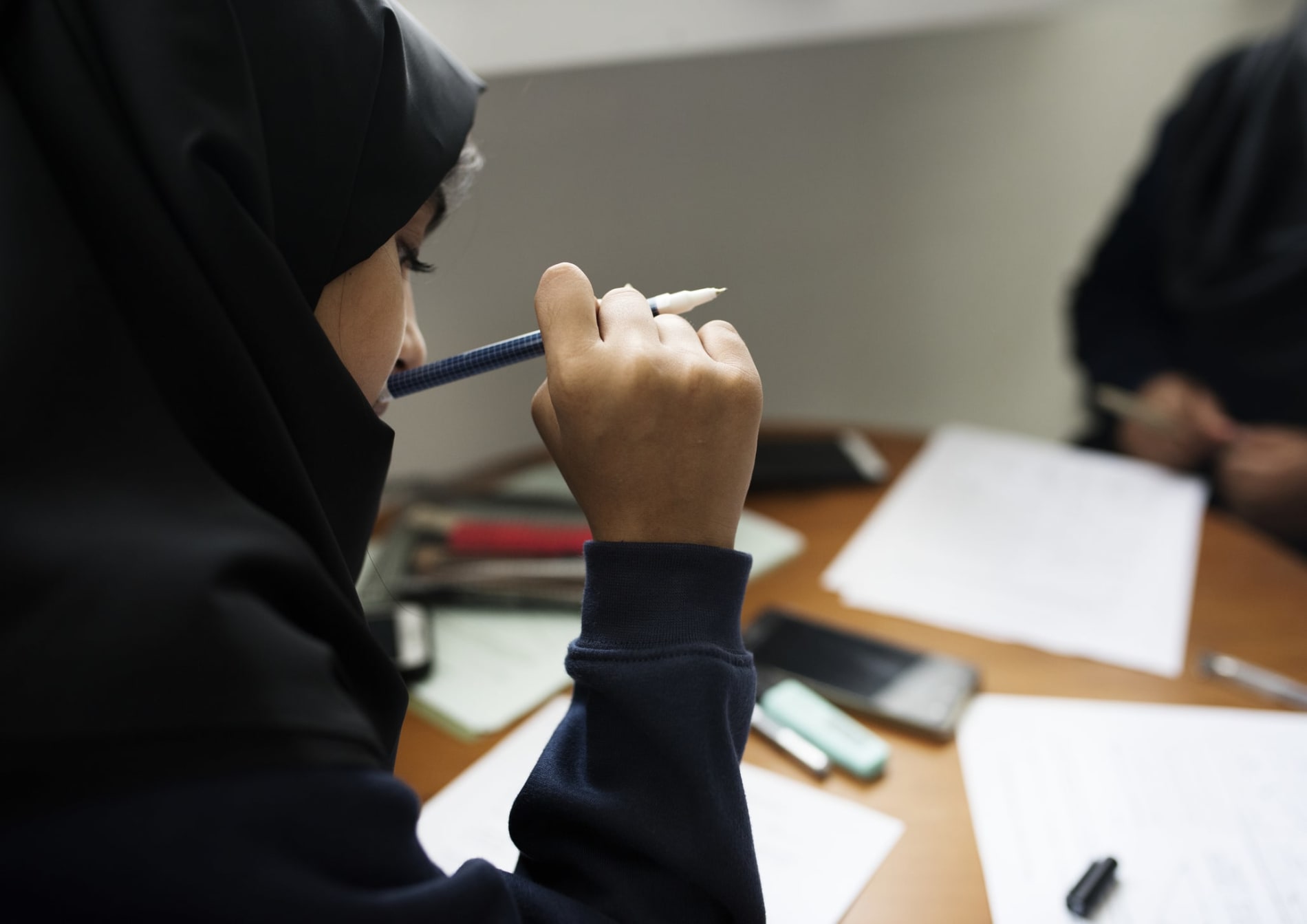 Young Muslim student doing schoolwork at her desk