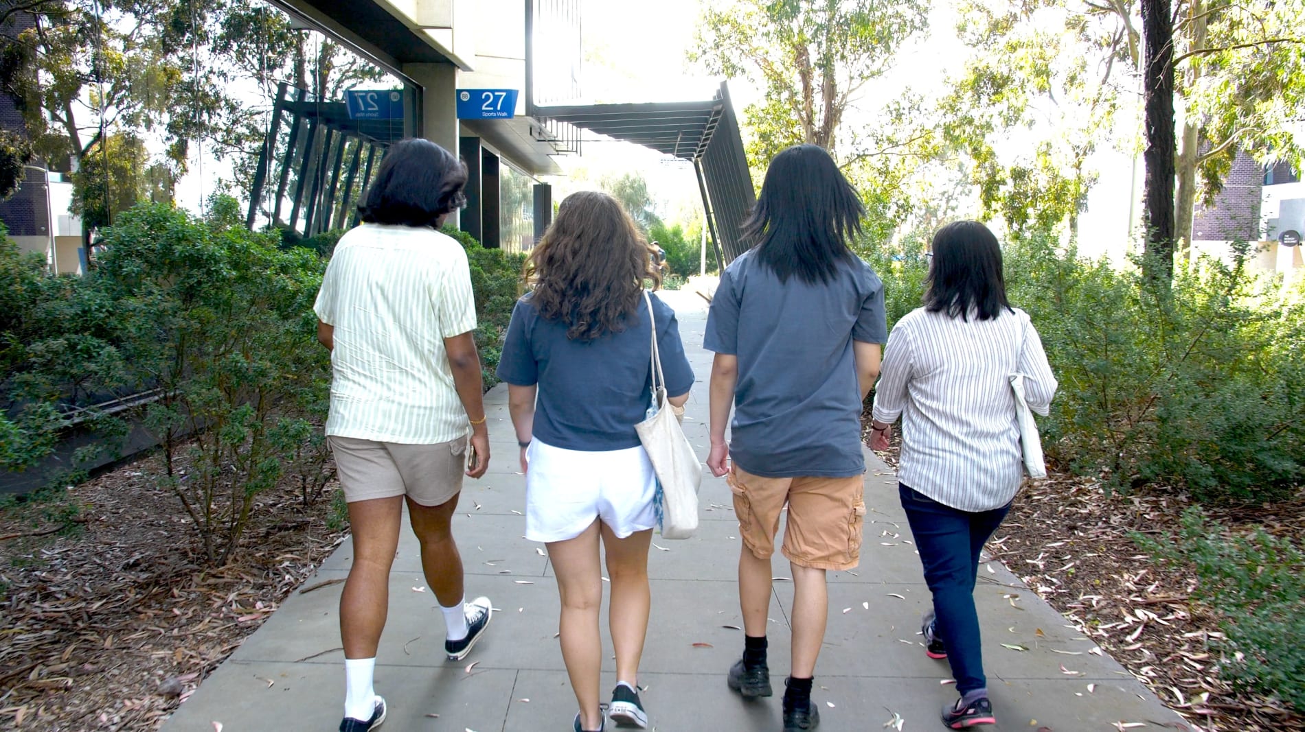 Young women walk across campus grounds.