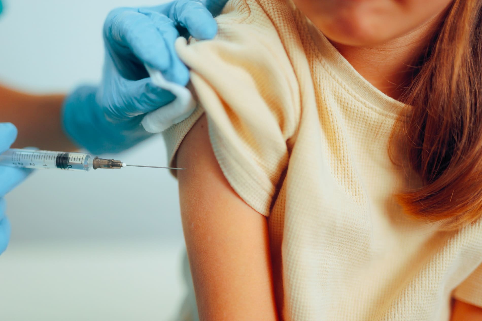 Nurse vaccinating a young girl. Influenza