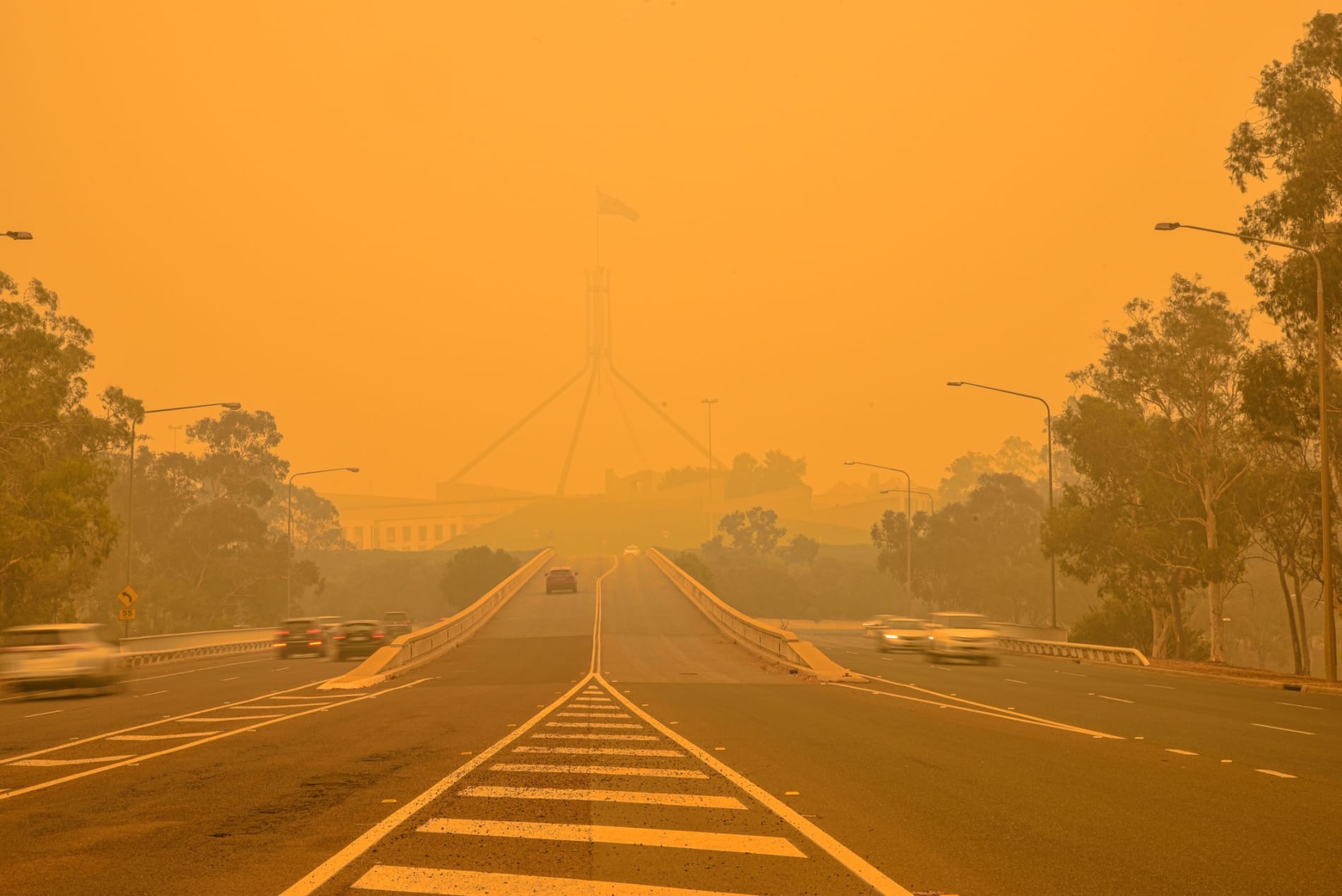 The Australian Parliament house is hardly visible behind a dense smog.