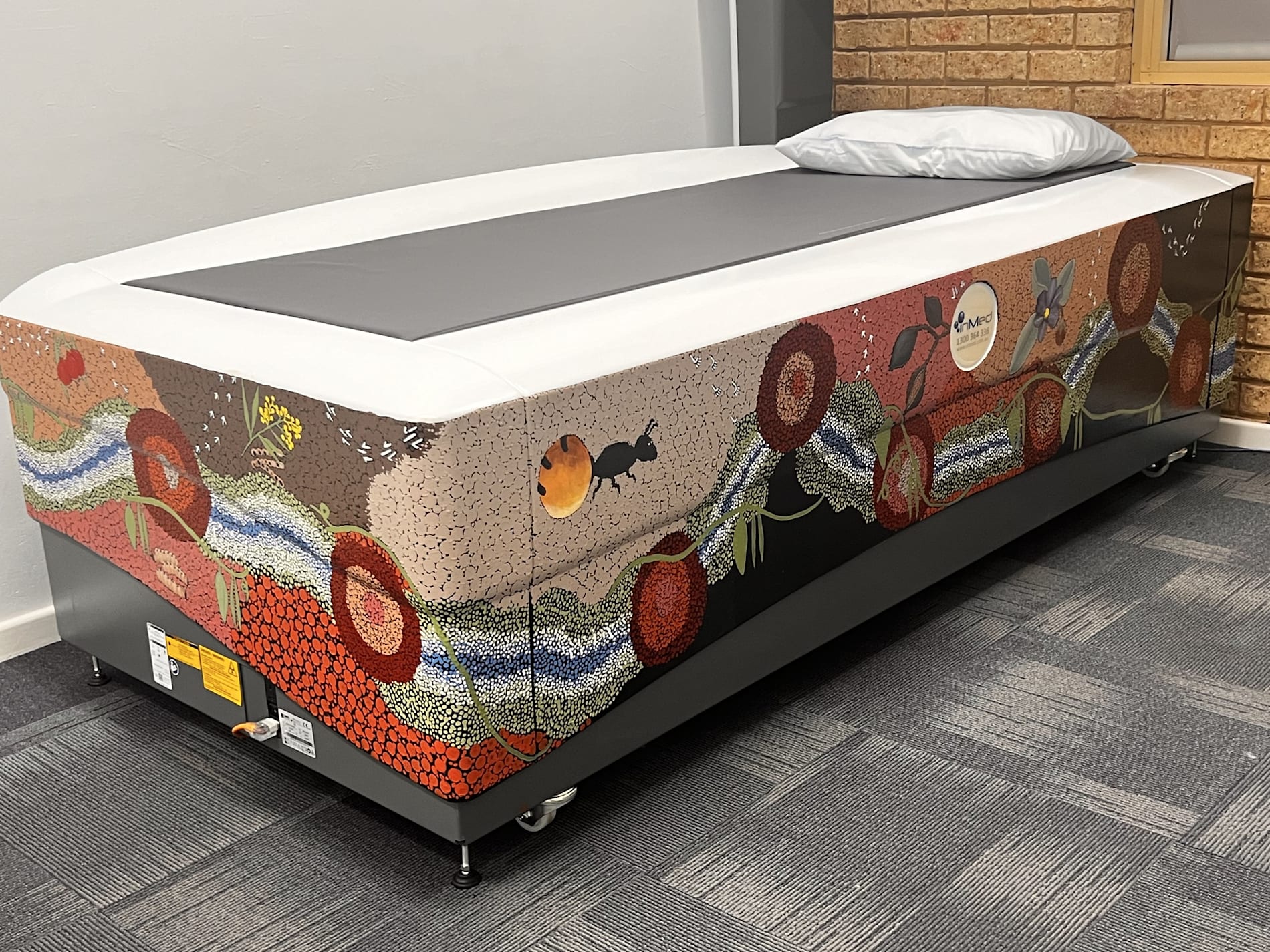 A bone imaging bed decorated with Indigenous art