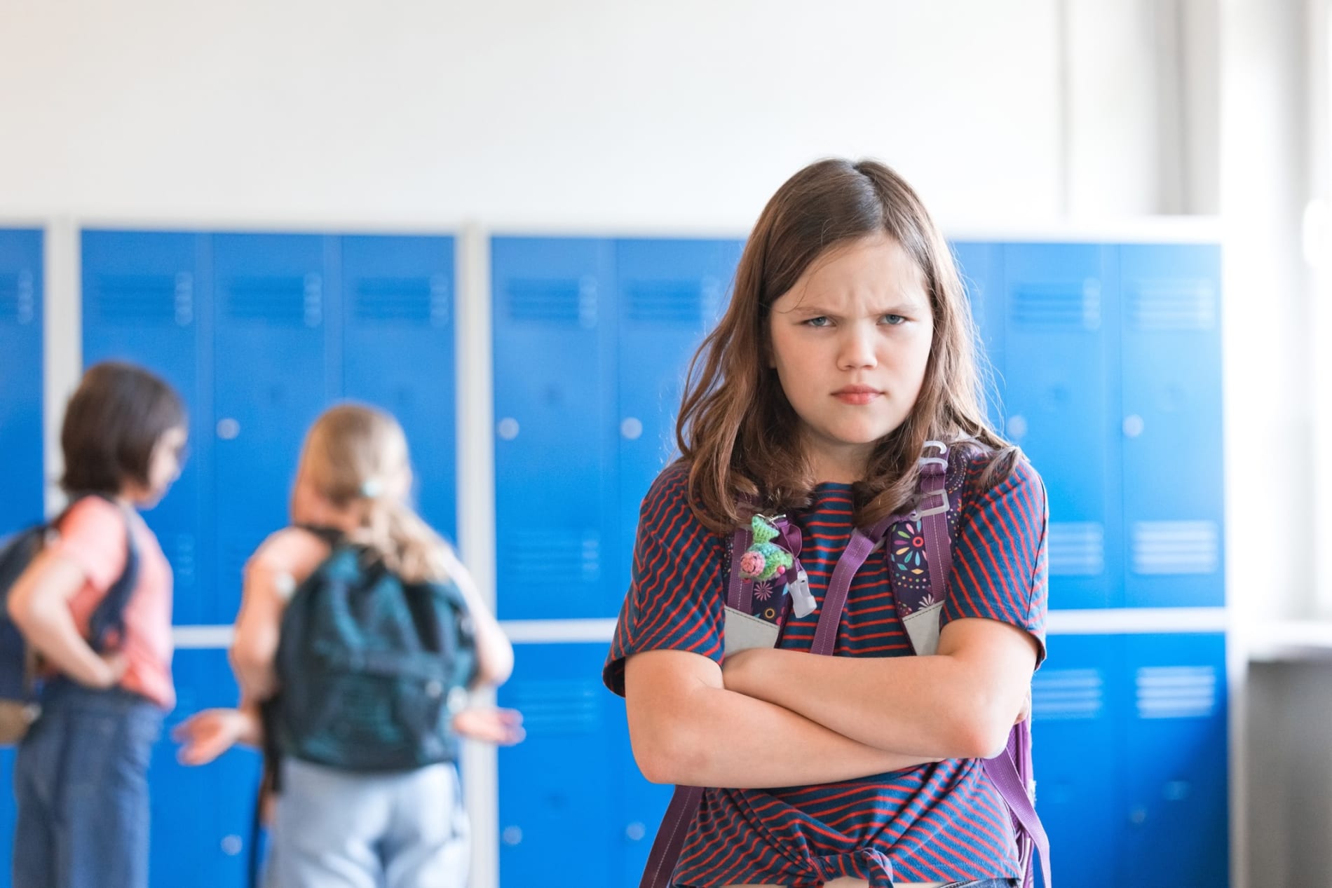 Angry girl standing at school corridor