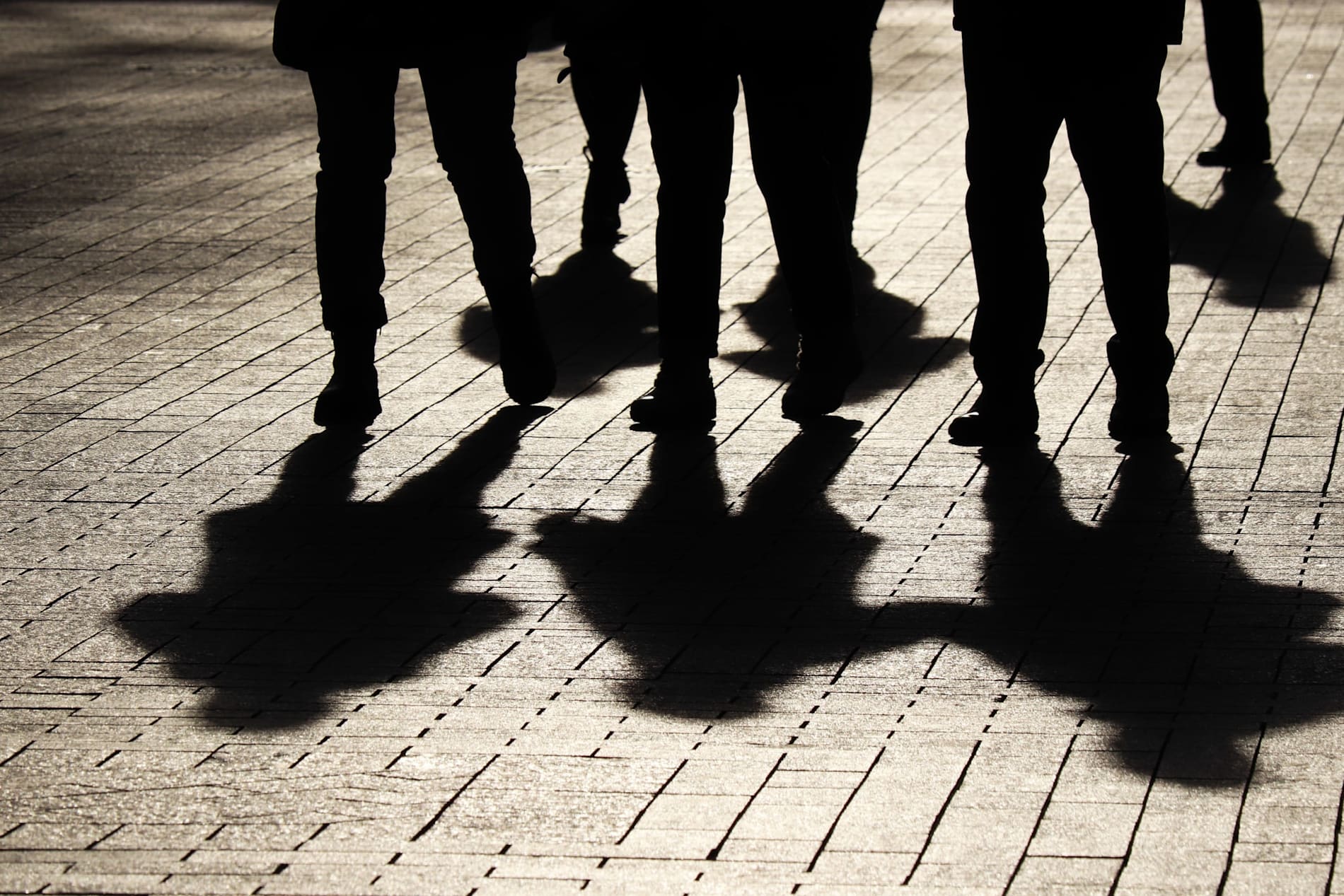 Silhouettes and shadows of young people on a darkened street