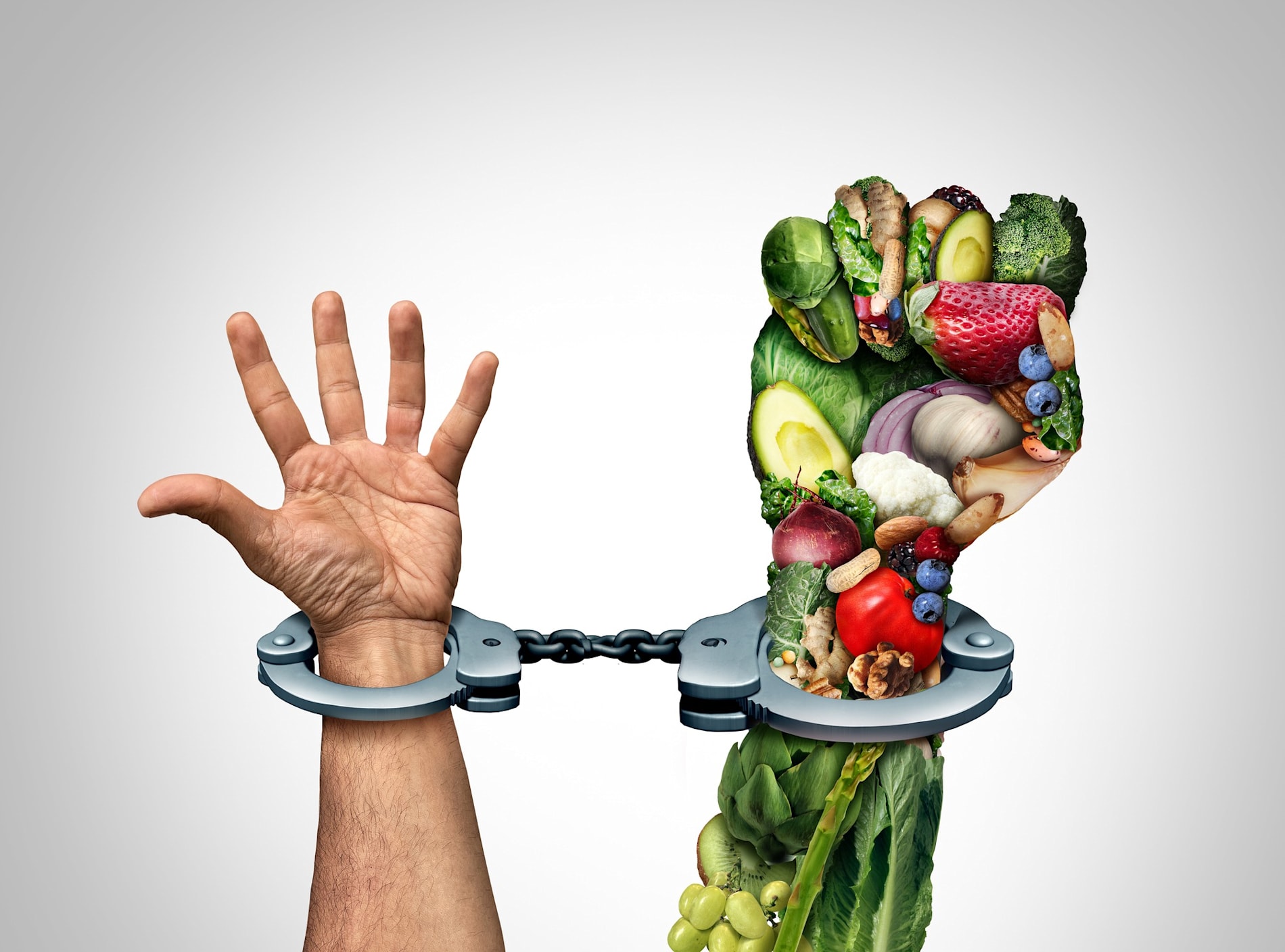 Human hands shackled in cuffs with fruits and vegetables.