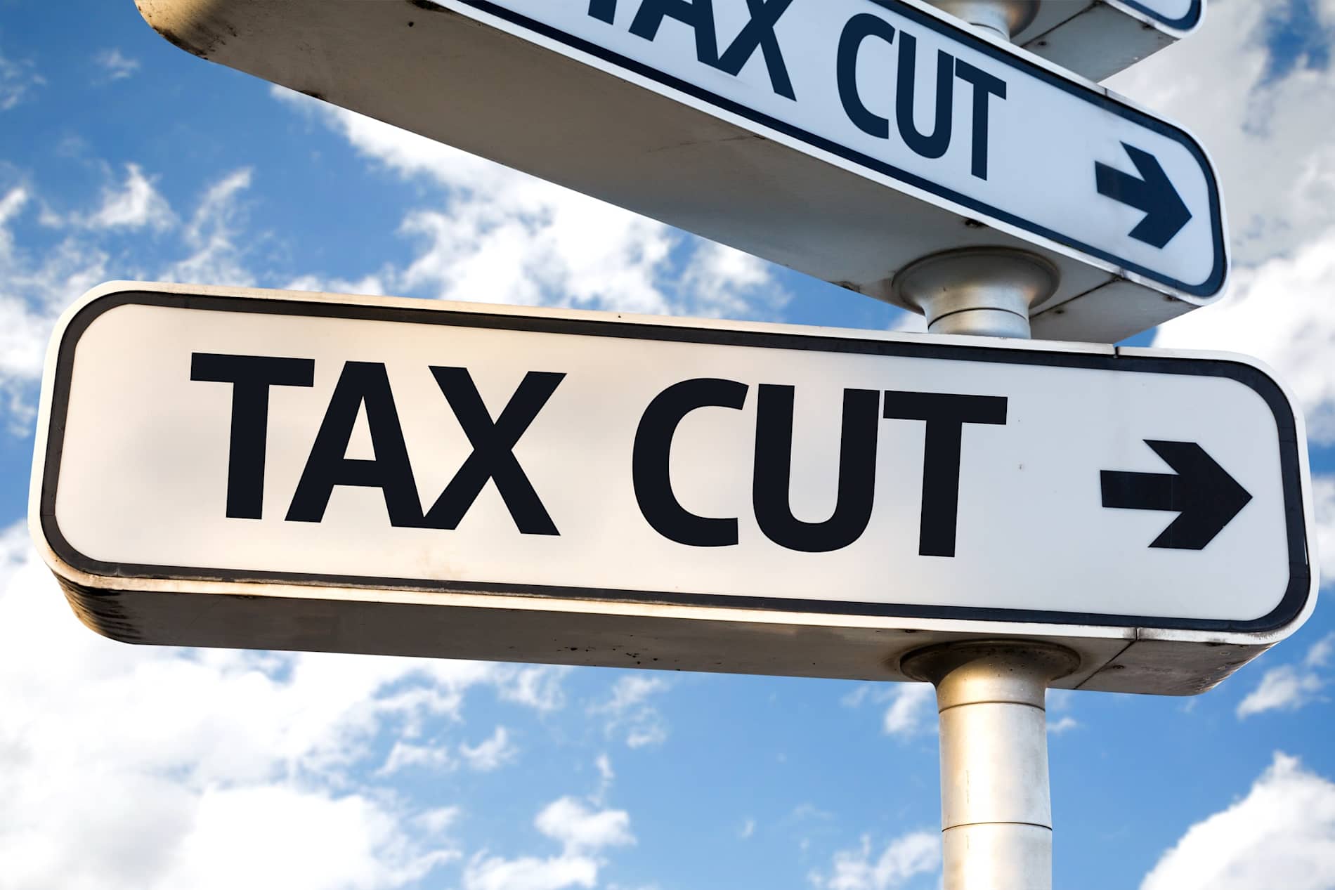 Signs pointing in different directions with the wor Tax written on them.