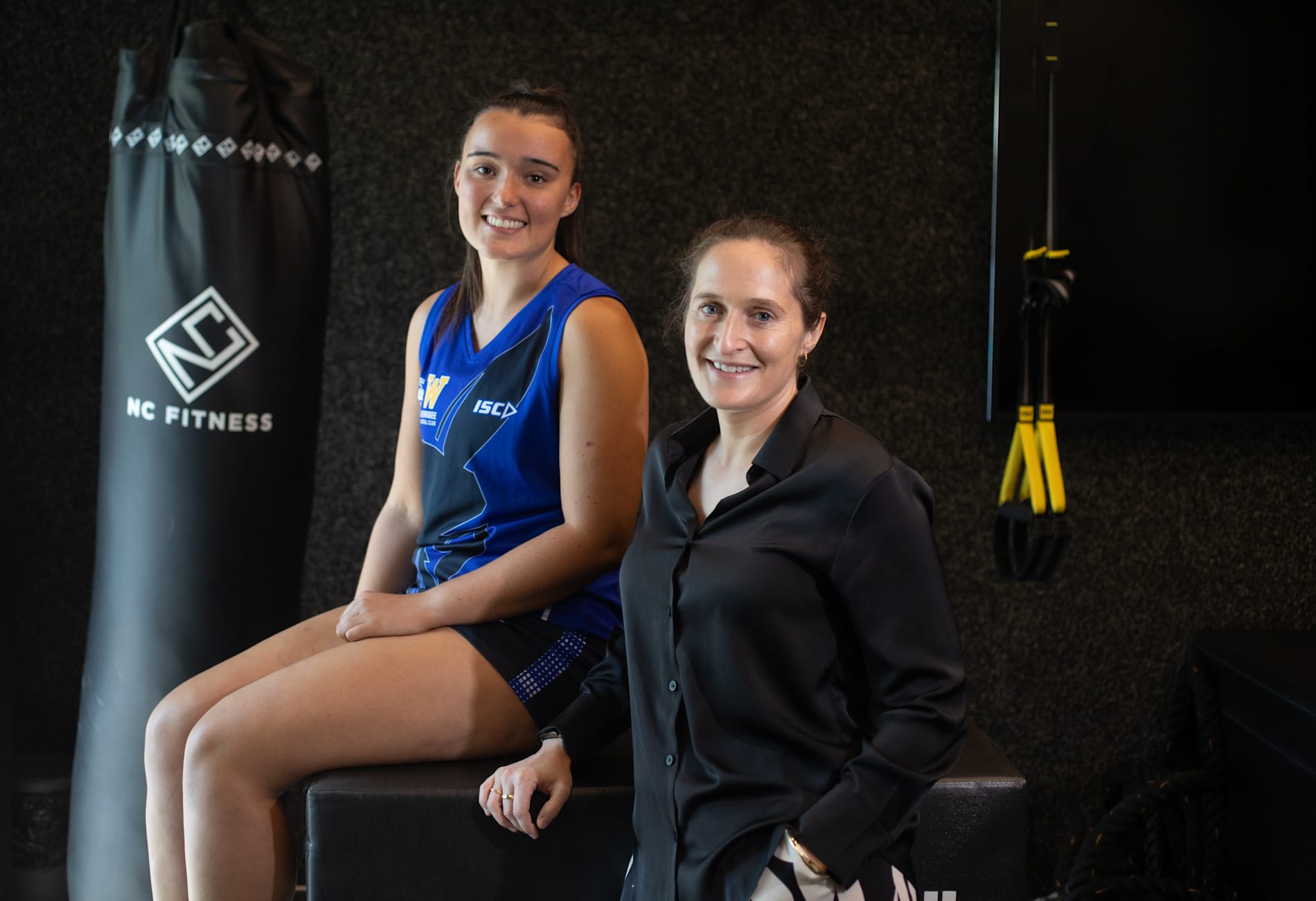 North Melbourne footballer Tricia Cowan and Dr Elise Facer-Childs smiling