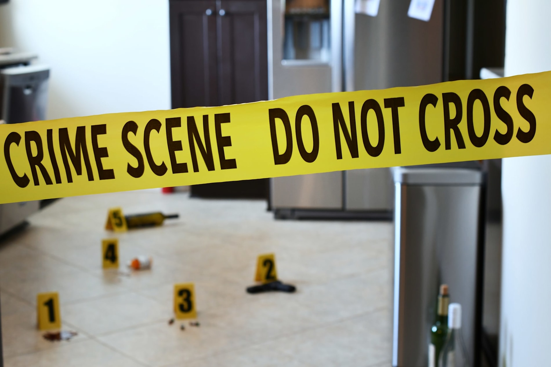 rime scene tape with a home interior in the background with evidence markers