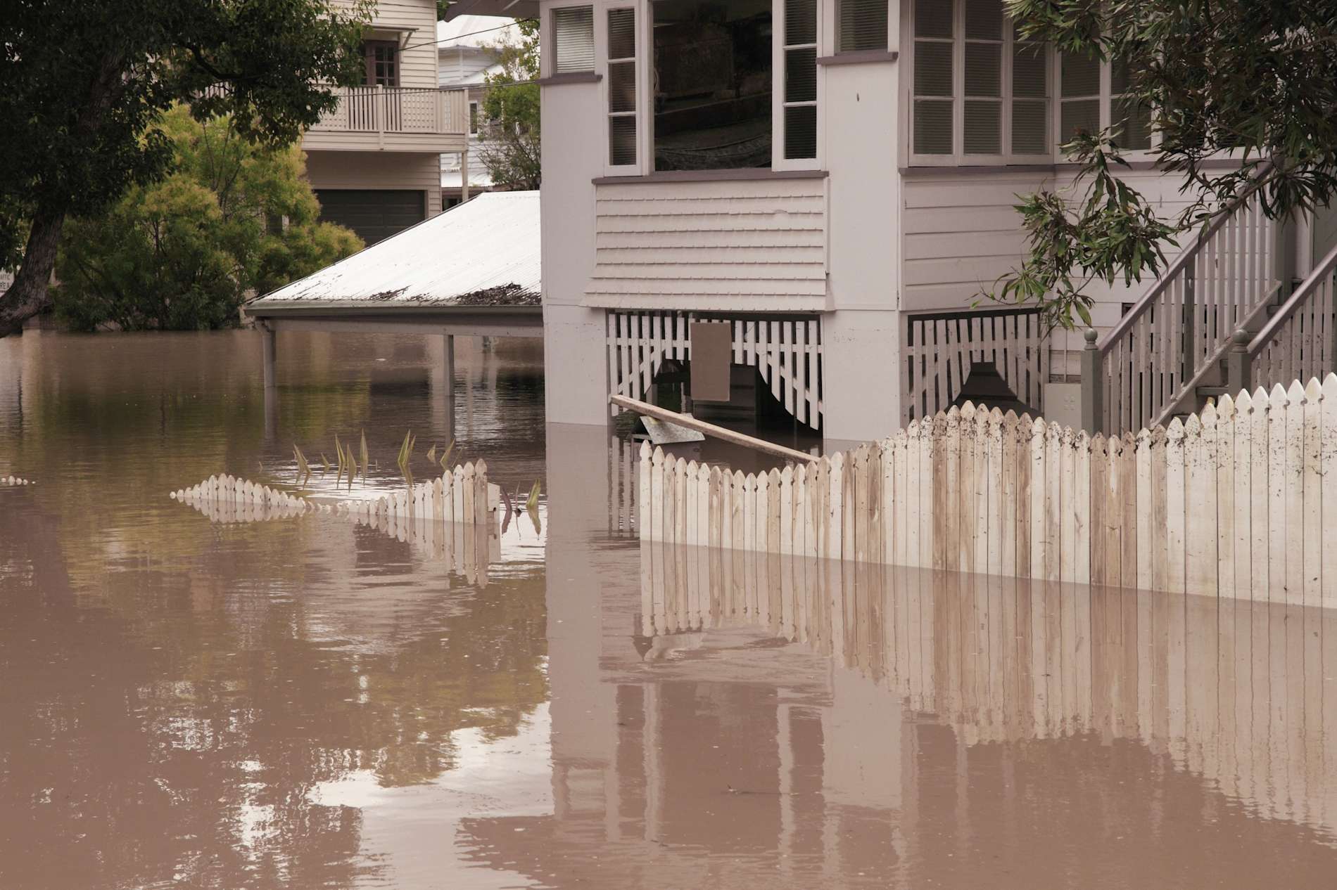 Landscape view of house flooded several feet deep.