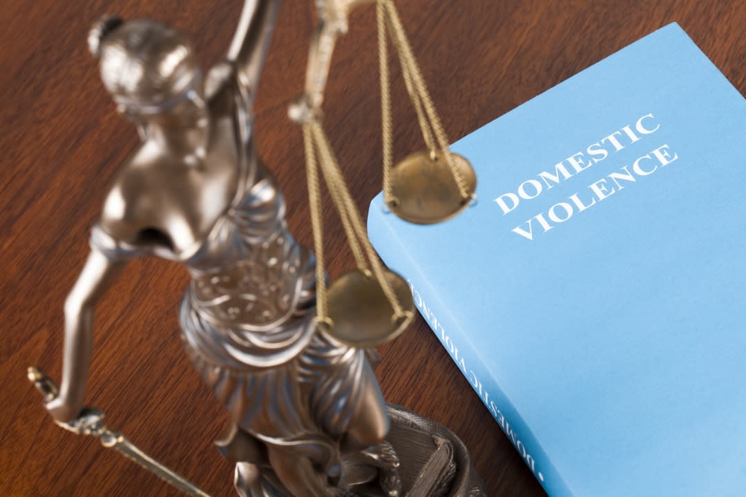 Scales of justice, with a domestic violence book