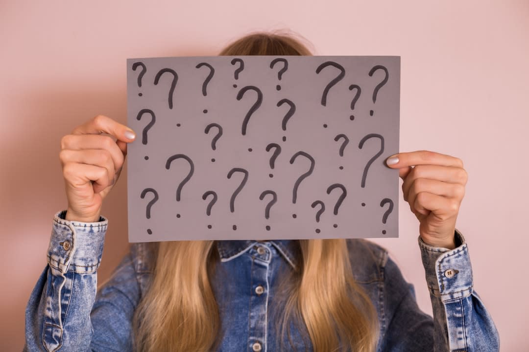 Woman holding cardboard with question mark