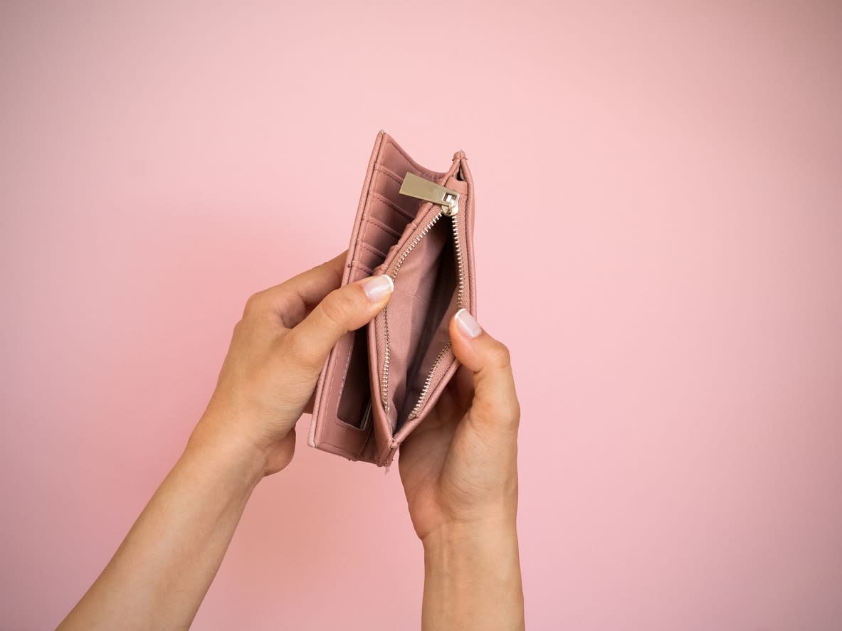 Woman's hands holding open an empty pink purse