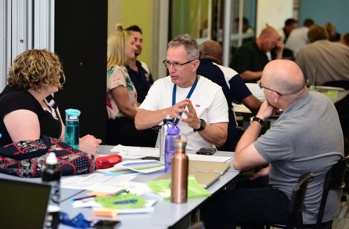 Three Knox School staff in discussion sitting at a table 