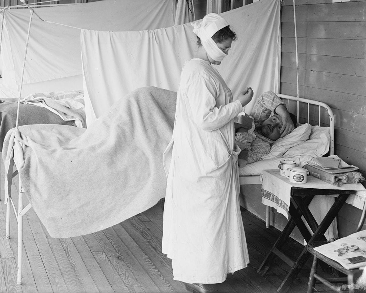 A nurse tends to a bed-ridden Spanish flu patient at Walter Reed hospital in the US in 1918