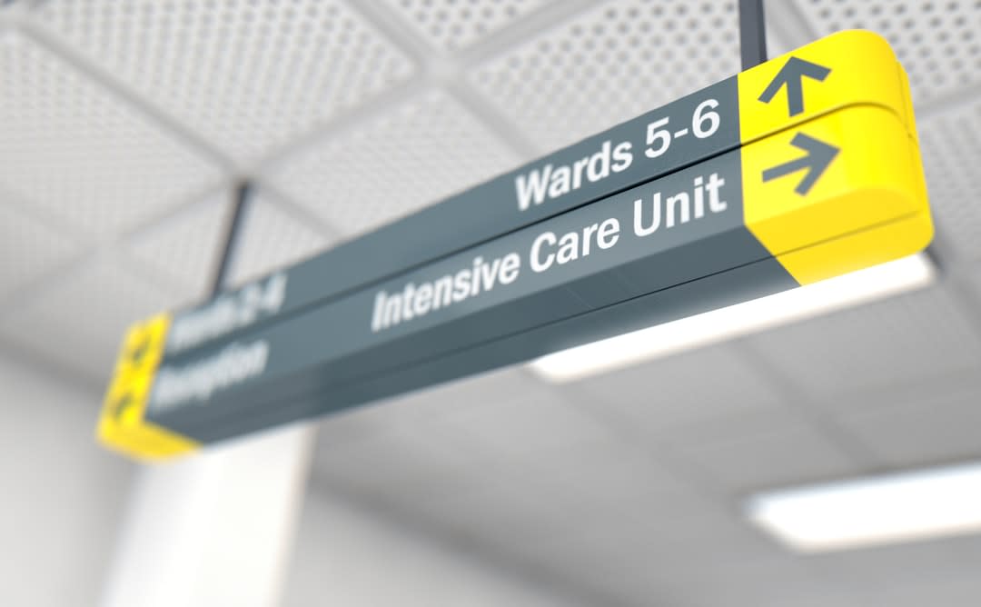 A yellow and grey intensive care ward sign in a hospital.