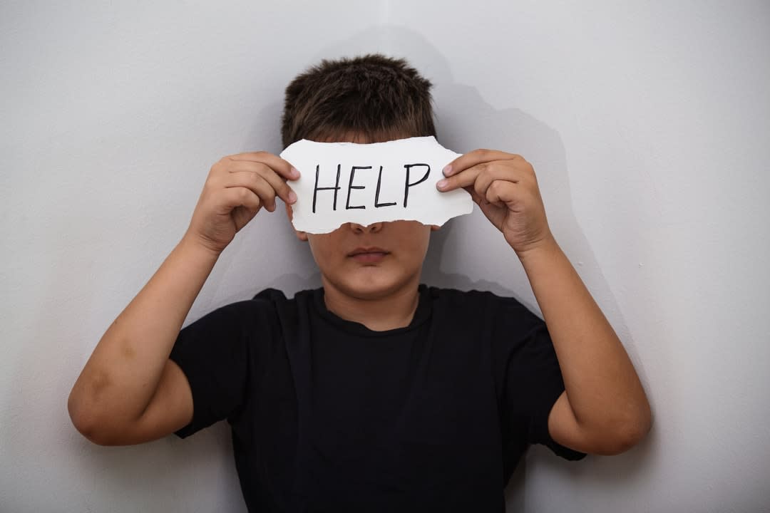 Teenager with help sign.