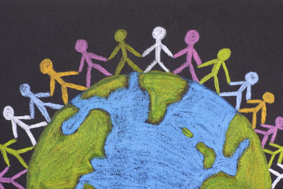 A chalk drawing of Earth, encircled by multi-coloured stick figures holding hands