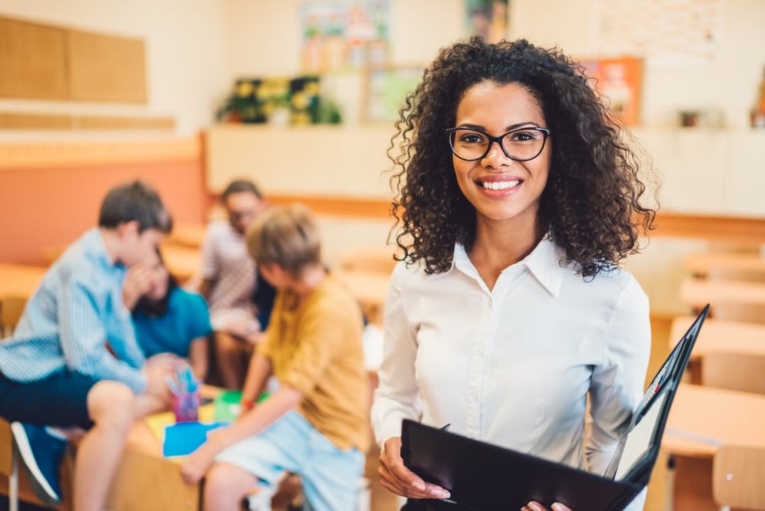 A teachers standing in front of a group of students in a classroom.