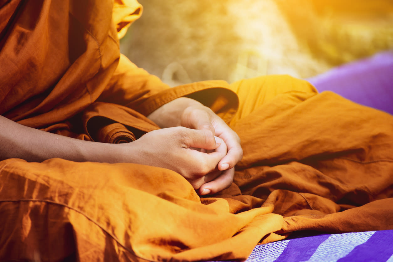 A Buddhist monk's hands clasped in a meditative pose