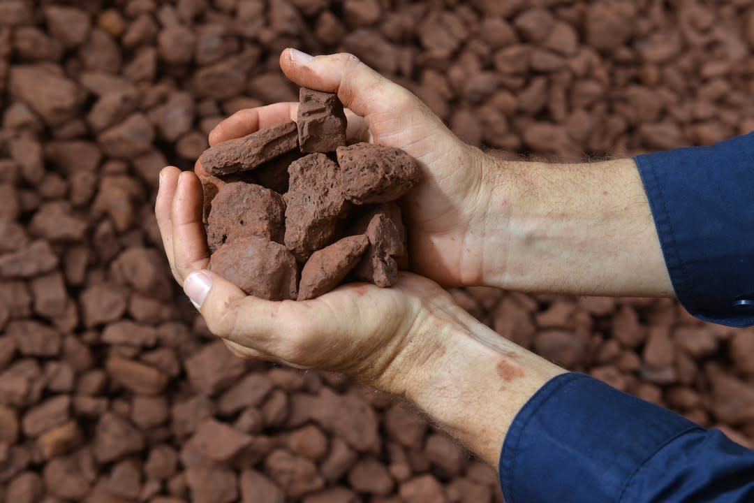 Two hands holding an iron ore sample