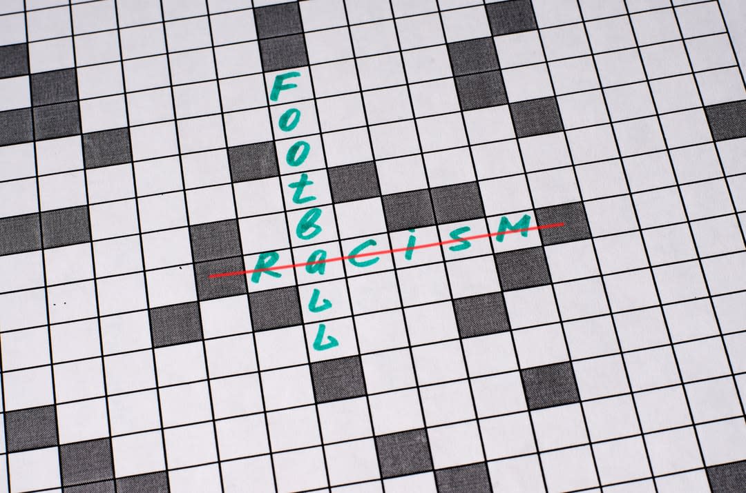 A crossword with the words ‘football‘ running down, and ‘racism‘, which is crossed out, running across through it