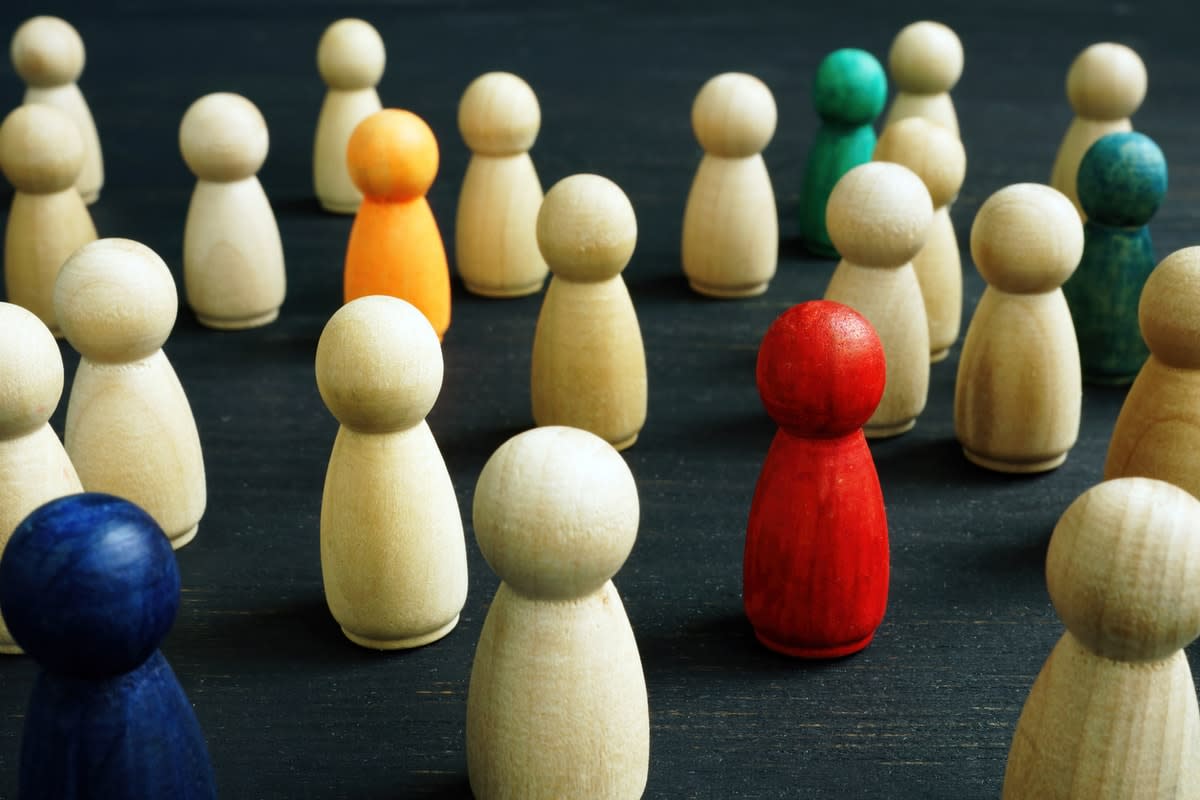 A group of miniature wooden skittles, some of different colours to signify multiculturalism 