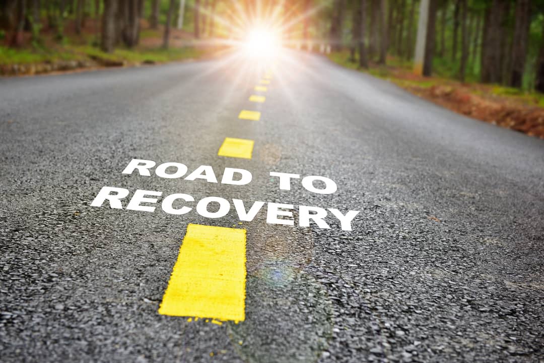 Road with the words road to recovery written across it