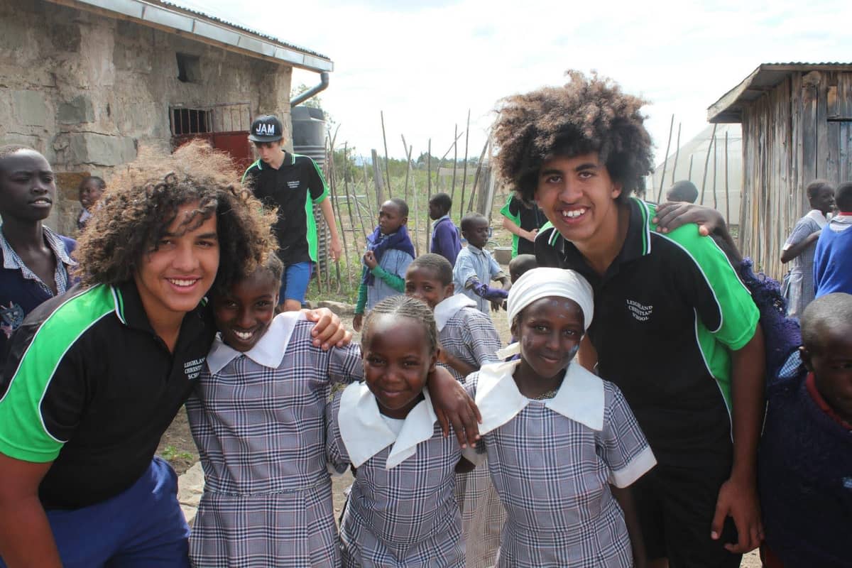 Jamali, then in Year 10, and Jomo Kigotho, Year 11, flanking three Kenyan schoolgirls on a school trip in Kenya.