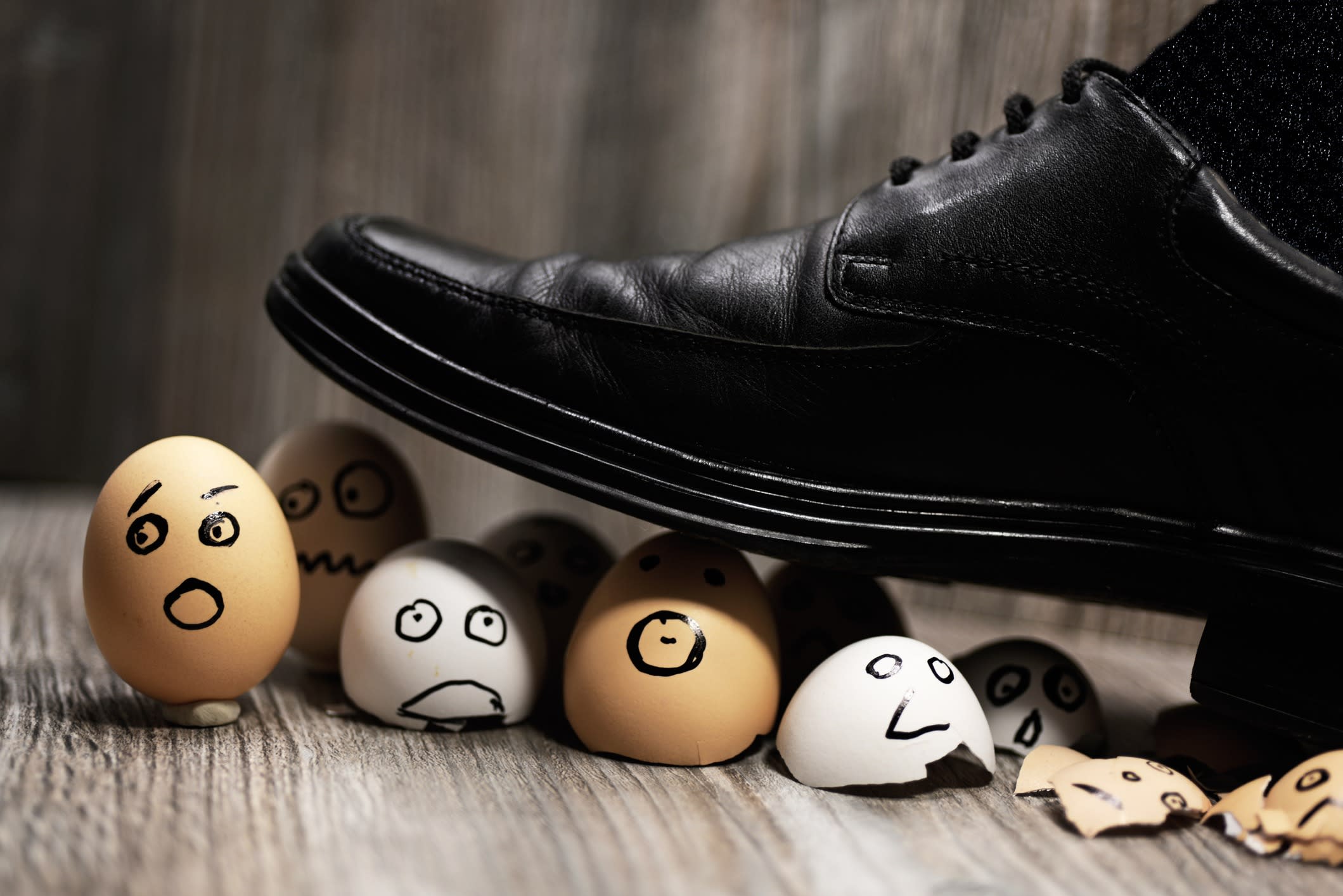 A businessman's show stepping on egg shells