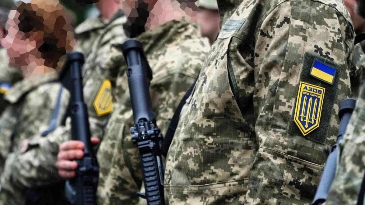 Azov soldiers lined up, with the focus on the trident emblem on the shoulder of one uniform 