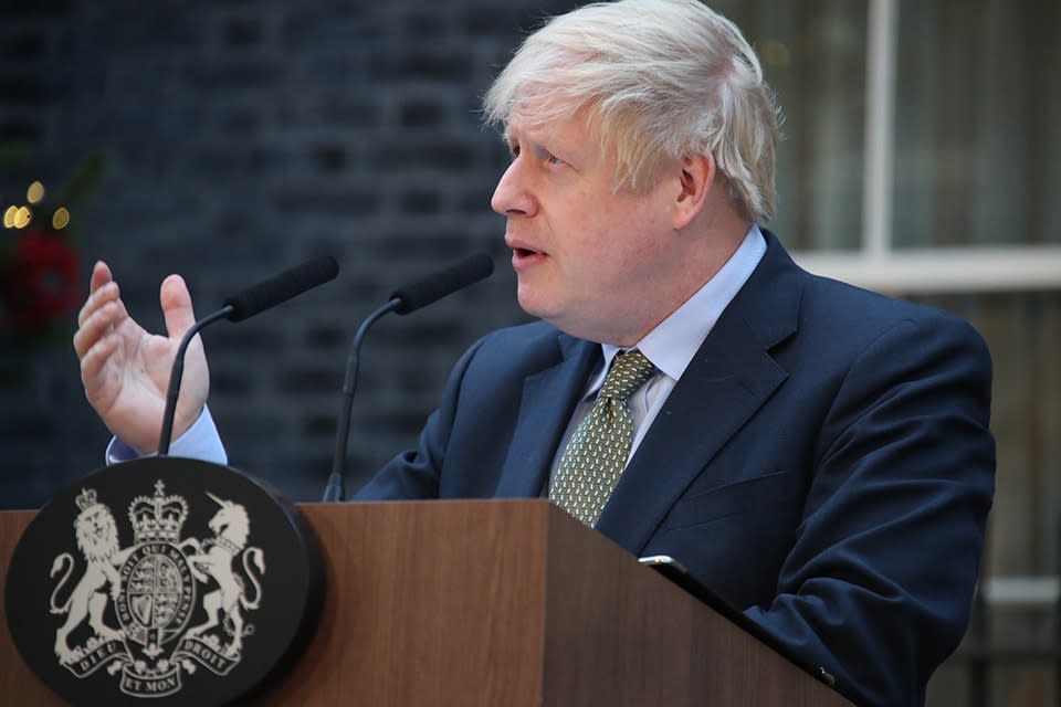 Boris Johnson speaking at a lectern outside