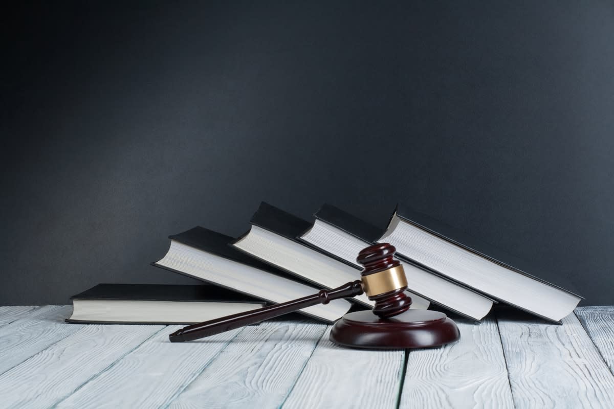 A hammer and gavel on a table with law books in the background 