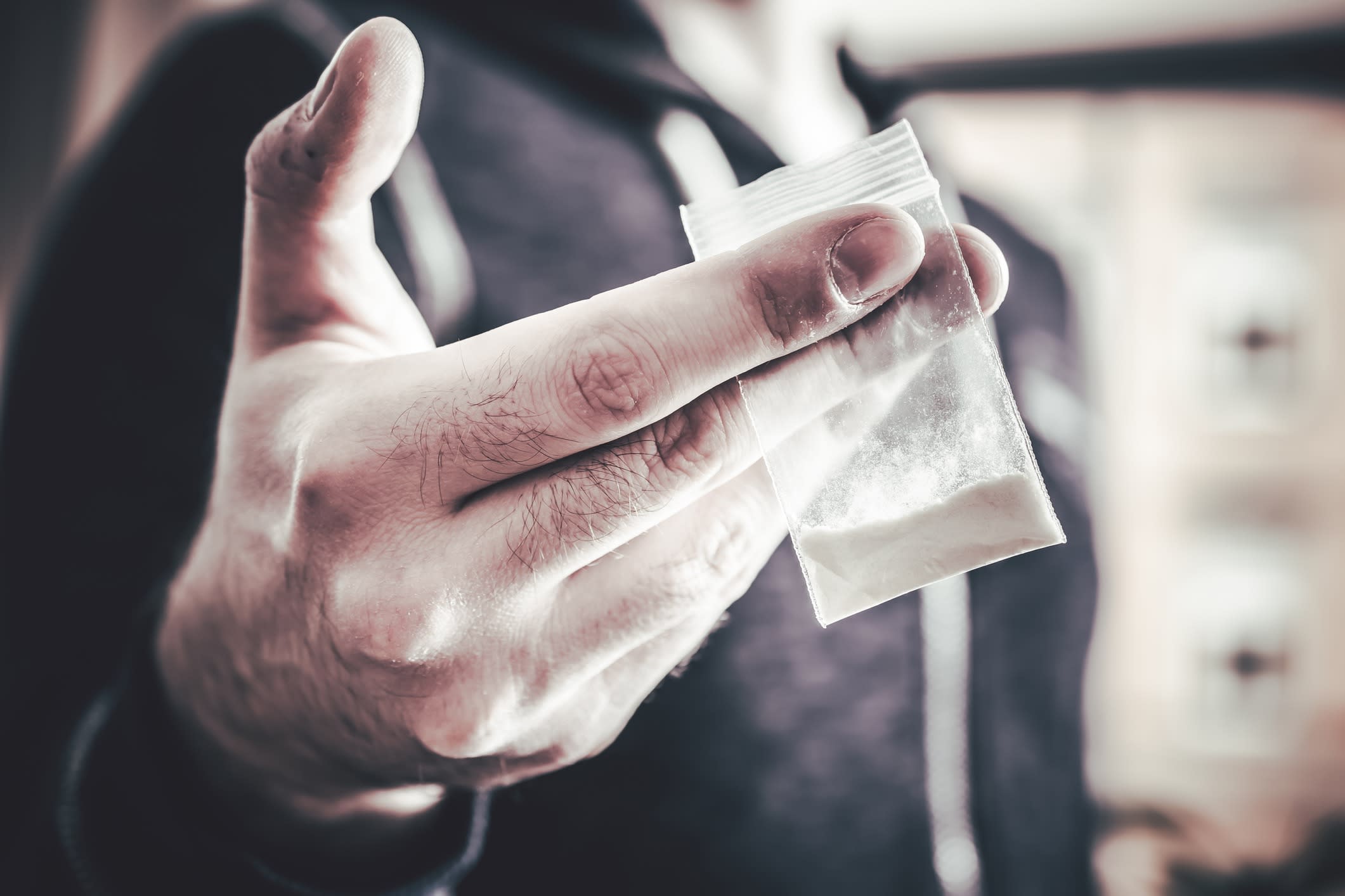 Dealing Drugs By A Man Holding One Little Bag With White Powder