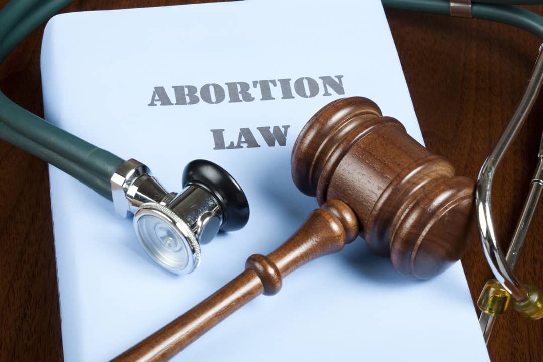 Gavel and stethoscope on Abortion law handbook.