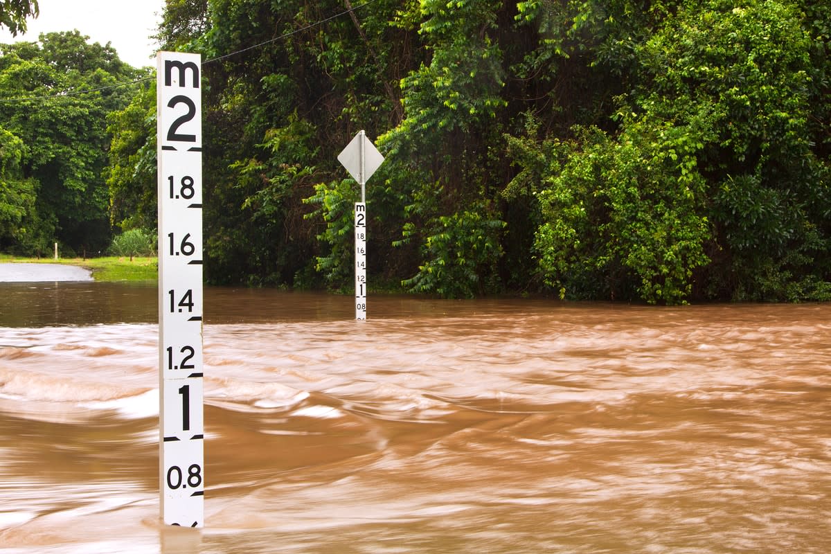 Flooded road with depth indicators visible above the water line