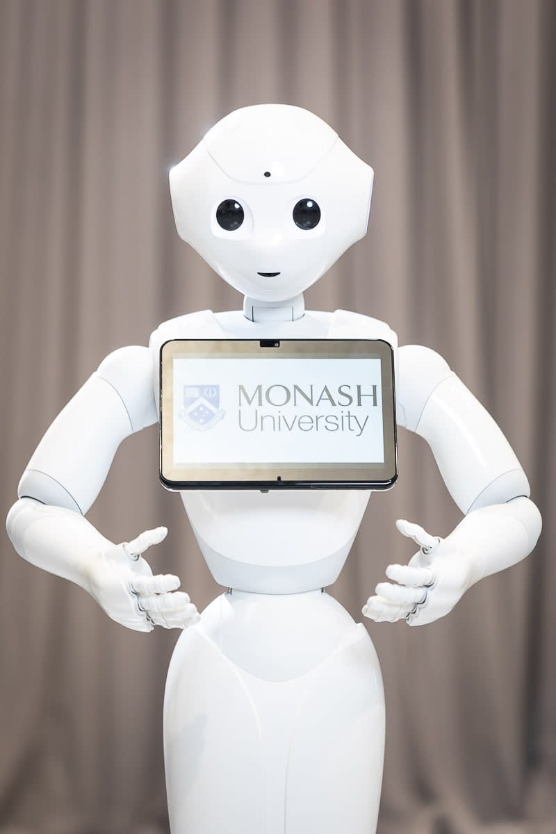 Pepper the robot, with an iPad reading 'Monash University' on its chest