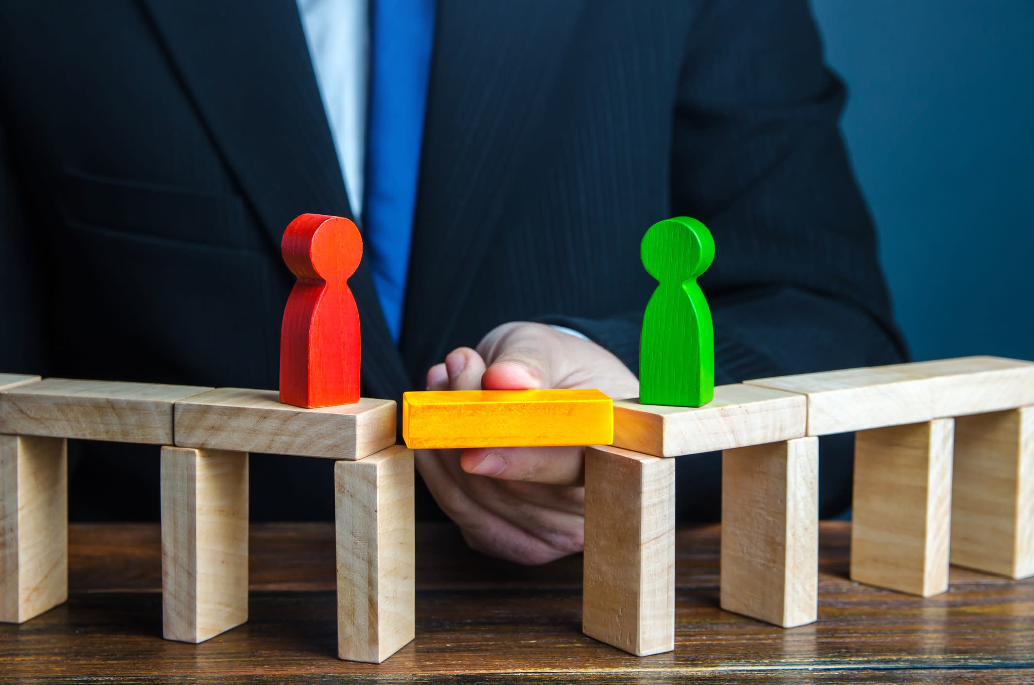 businessman builds a bridge between two people.