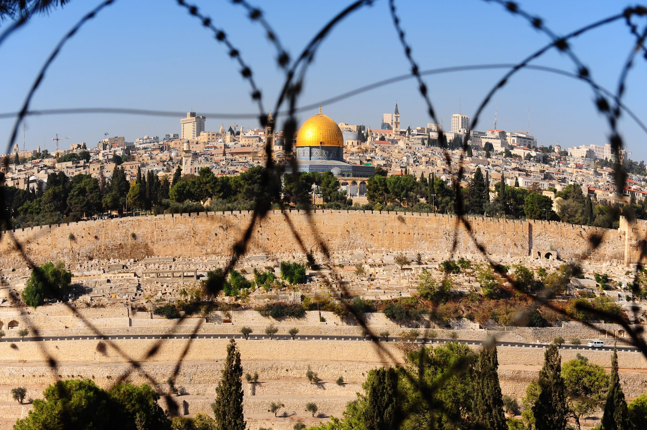 View from the Mount of Olives on the dome of the rock and ancient cemetery through the barbed wire