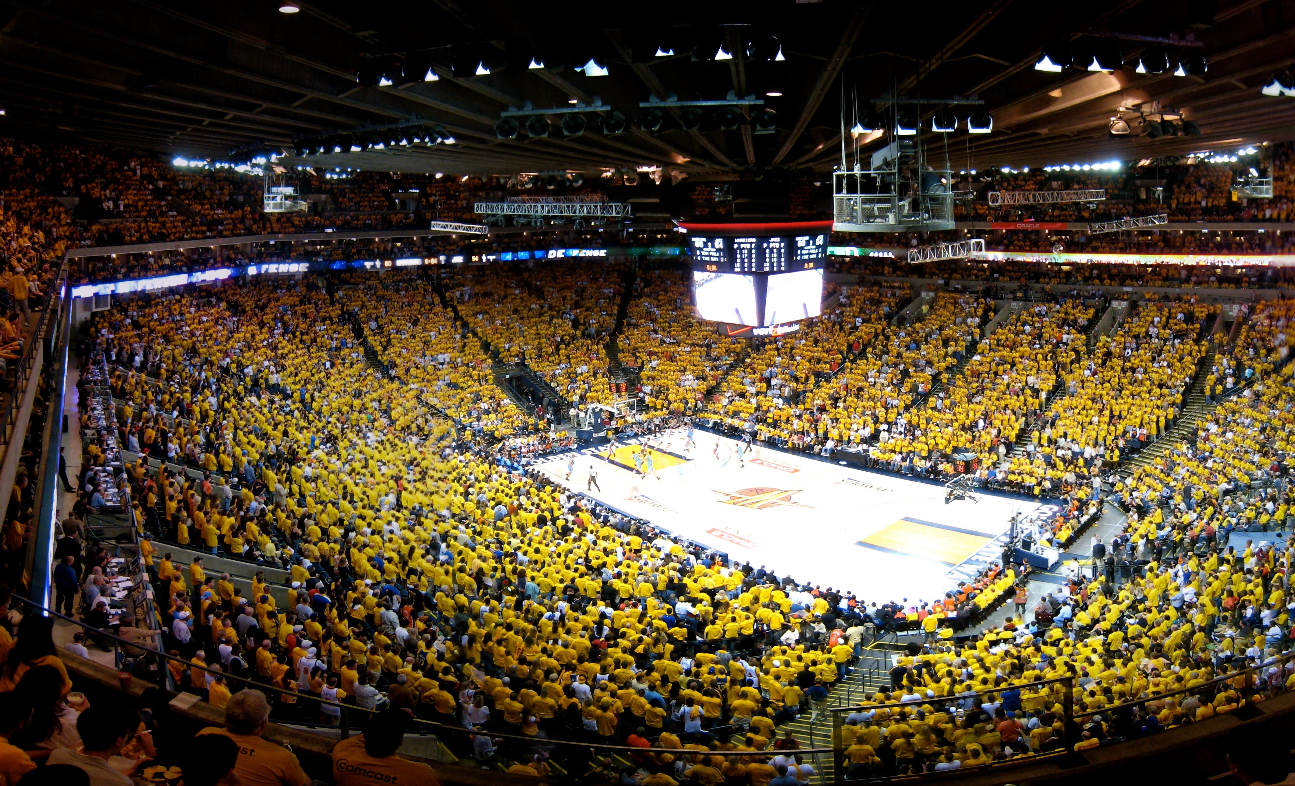 A crowded basketball stadium filled with supporters from one team.