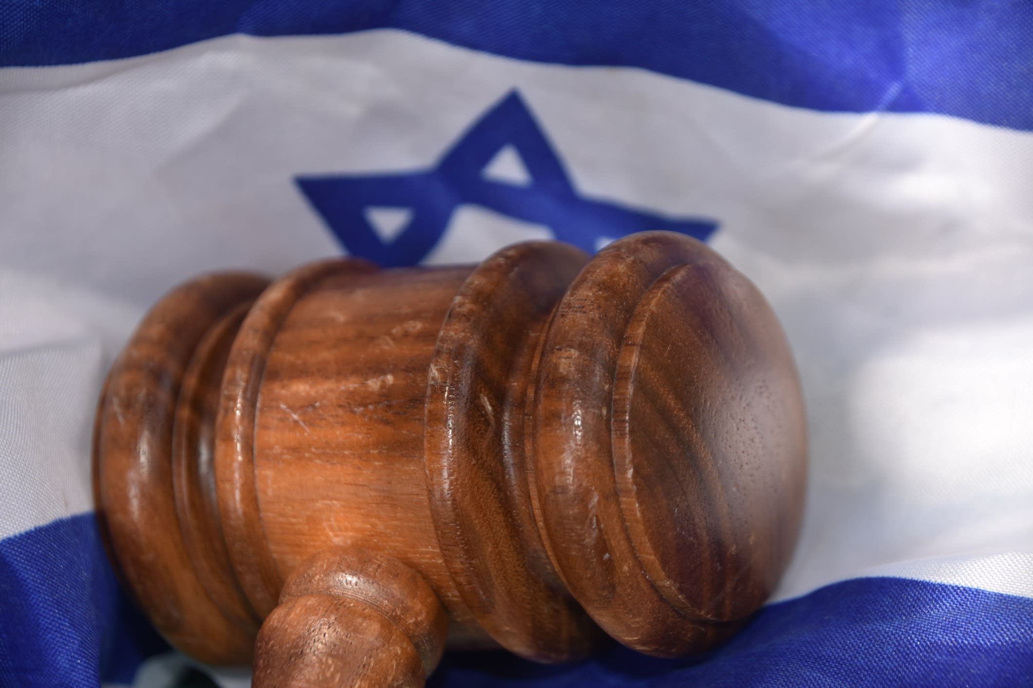 Gavel against an Israeli flag background.