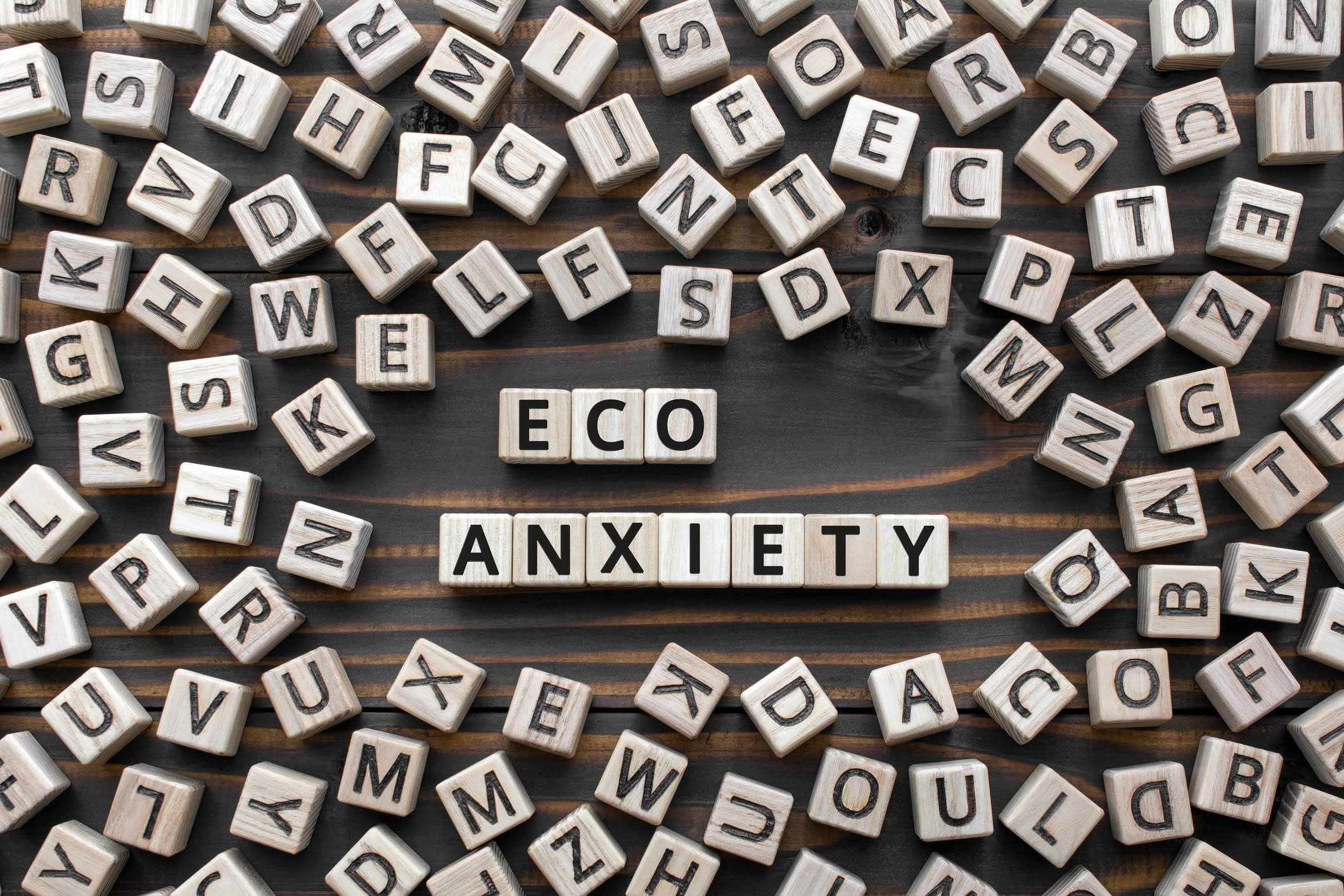 Lettered tiles spell out the phrase eco-anxiety: 