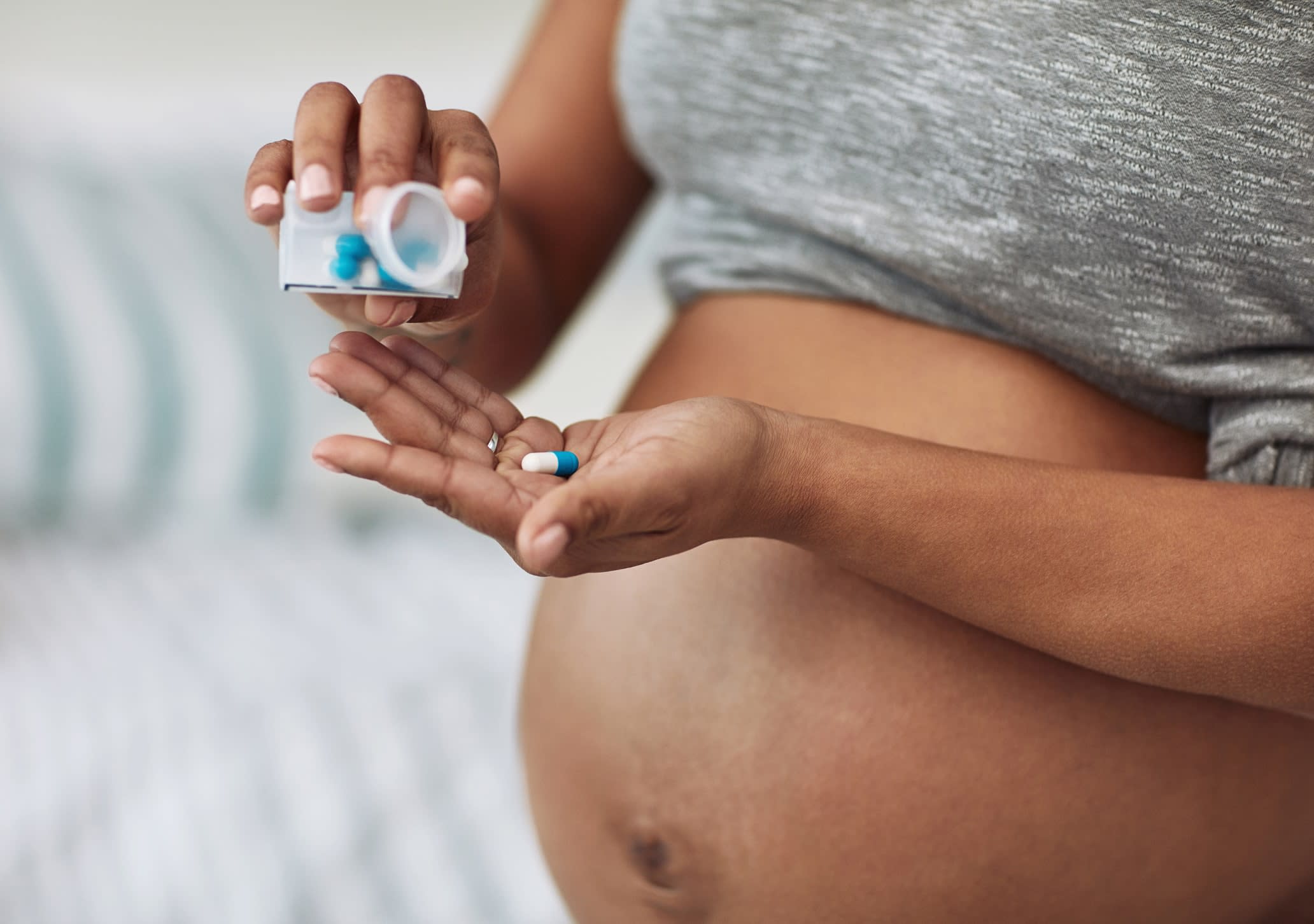 Cropped shot of an unidentifiable pregnant woman taking medication