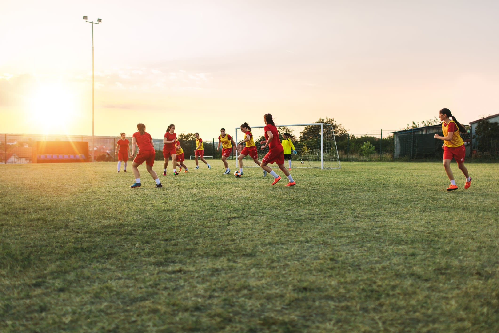 Girls training on a soccer field at dusk